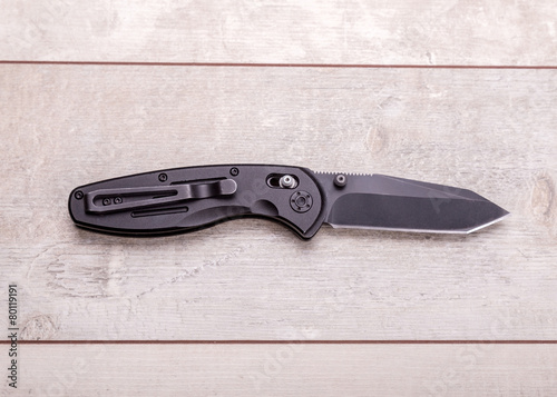 Folding knife on a wooden background