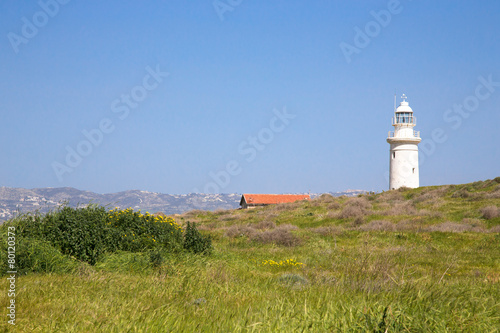 Green meadow, lighthouse, roof of the house and mountains in the © strannik_fox