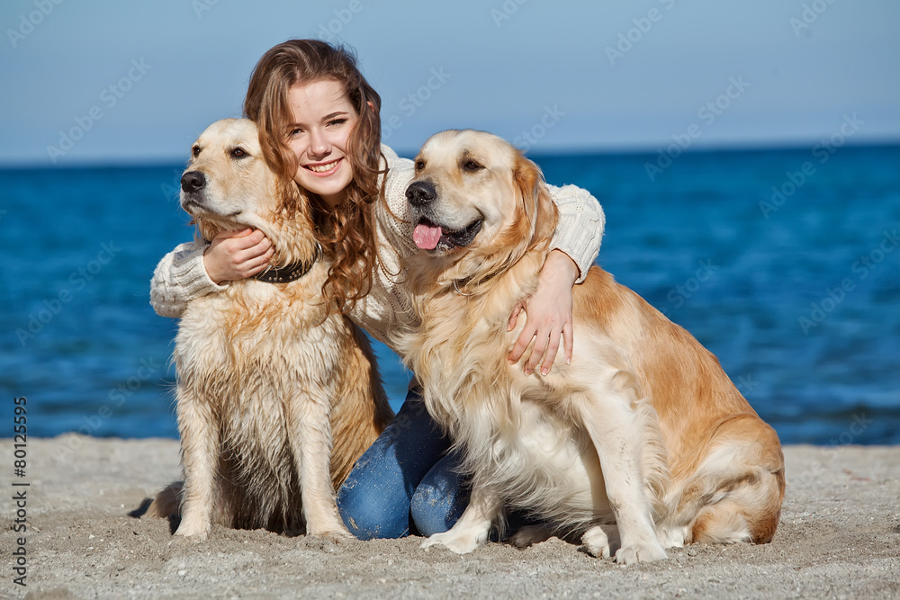 woman are playing whit two dogs on the beach 