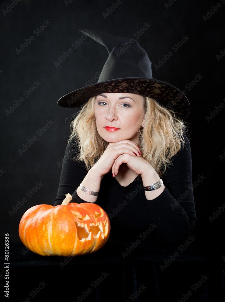 The charming witch cooks the potion on the eve of Halloween. The charming witch cooks the potion on the eve of Halloween.