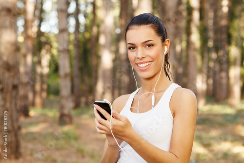 Young woman listening to music through earbuds