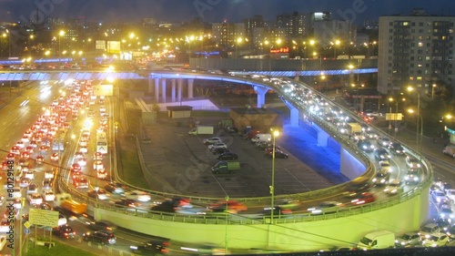 Illuminated bridge with car traffic and parking lot. Timelapse photo