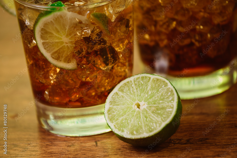 drink concept - cocktail with cola ice cubes and lime drink concept - cocktail with cola ice cubes and lime