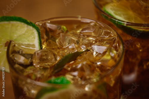 drink concept - cocktail with cola ice cubes and lime