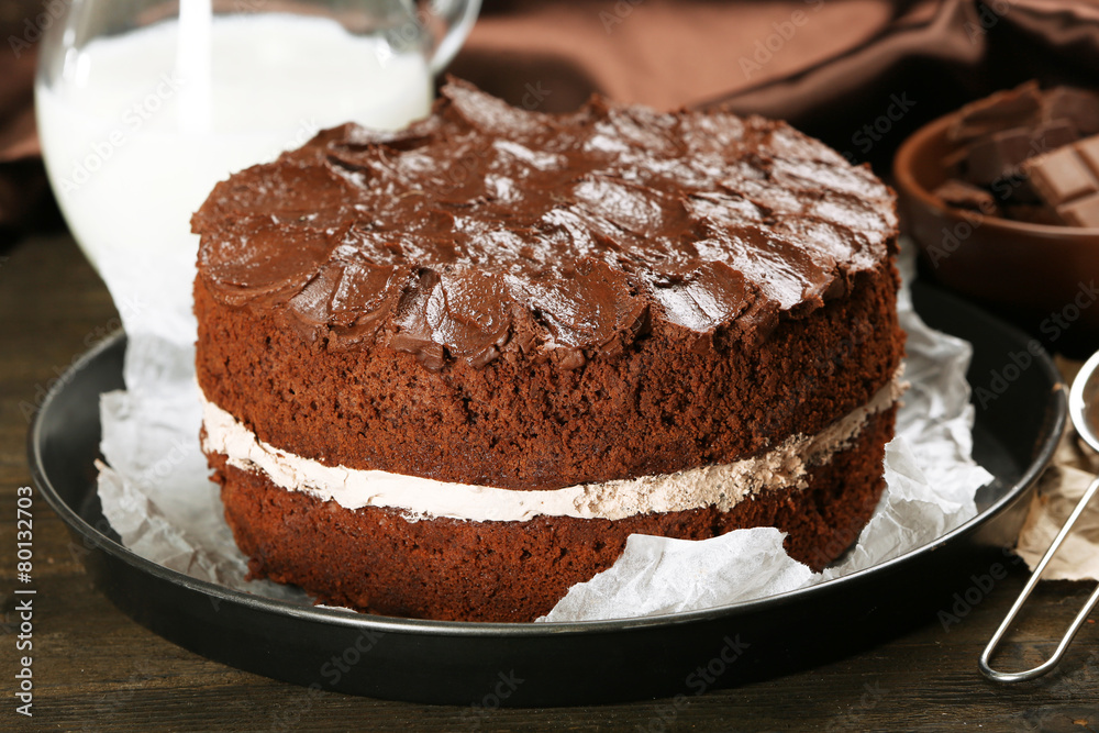 Delicious chocolate cake on table on brown background Delicious chocolate cake on table on brown background