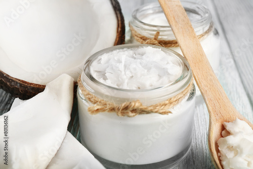Fresh coconut oil in glassware and wooden spoon