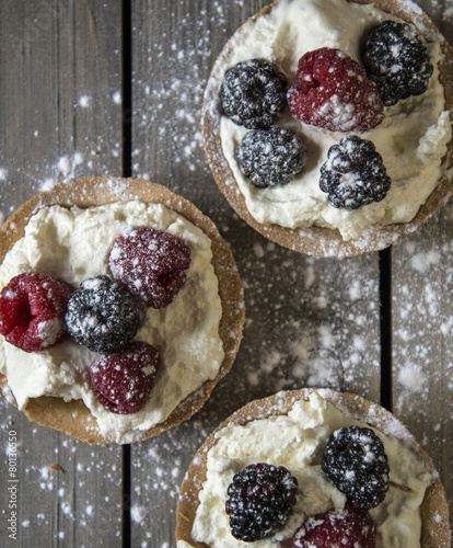 Fresh fruit tartlets on rustic wooden kitchen background photo