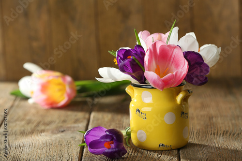 Fototapeta Naklejka Na Ścianę i Meble -  Beautiful spring flowers in yellow pot on wooden background