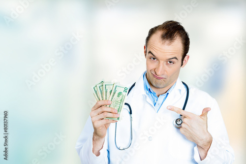 Fotografie Greedy health care professional male doctor holding money dollar