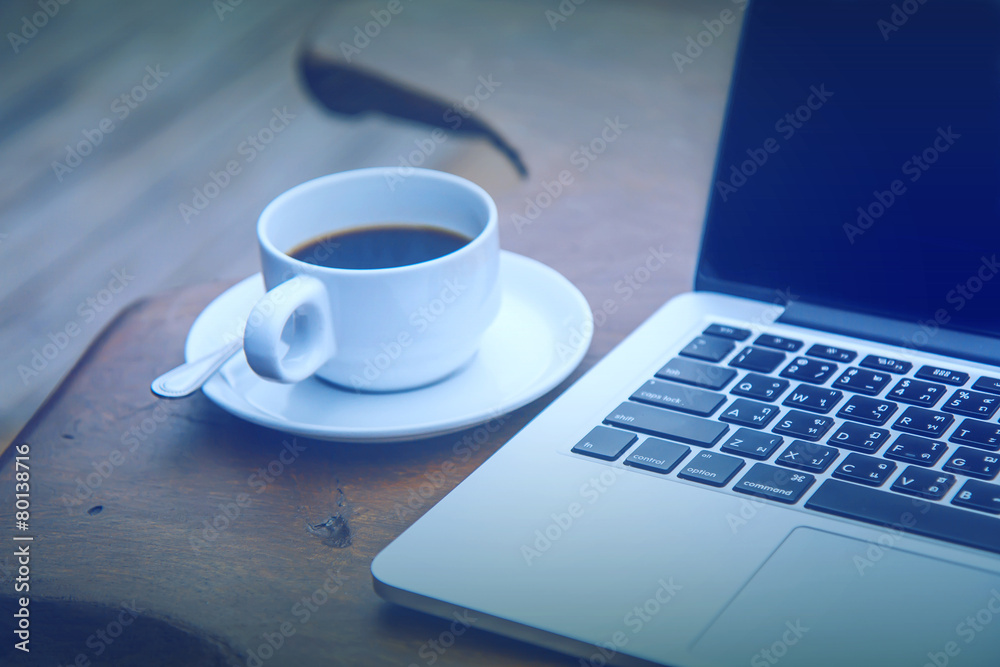 Black coffee in a white cup on a table with a computer. Black coffee in a white cup on a table with a computer.