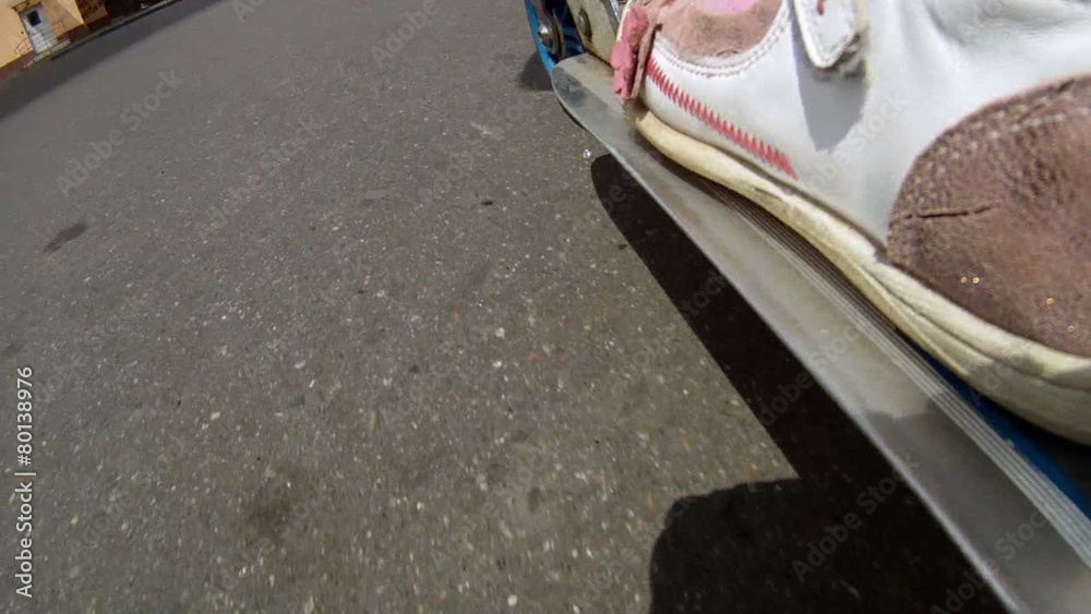 Girl goes for a drive on scooter at playground on asphalt