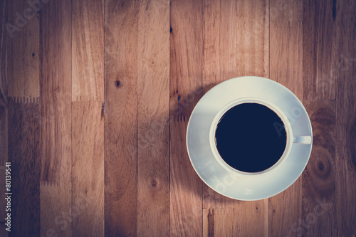 Top view of black coffee in the cup on wooden table 