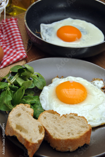 Fried eggs with plate, bread, and oilcan