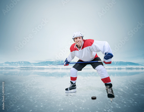 Hockey player on the ice surface of lake