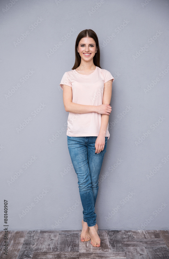 Full length portrait of a happy woman leaning on the wall Full length portrait of a happy woman leaning on the wall