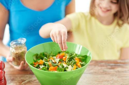 close up of happy family cooking salad in kitchen