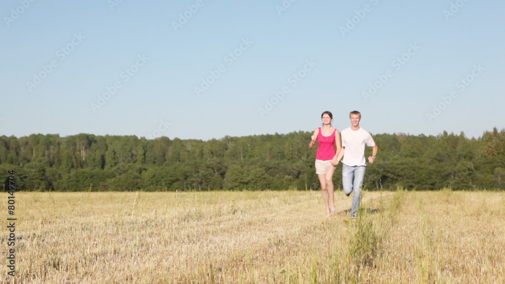 guy with girl run across field keeping for hands guy with girl run across field keeping for hands