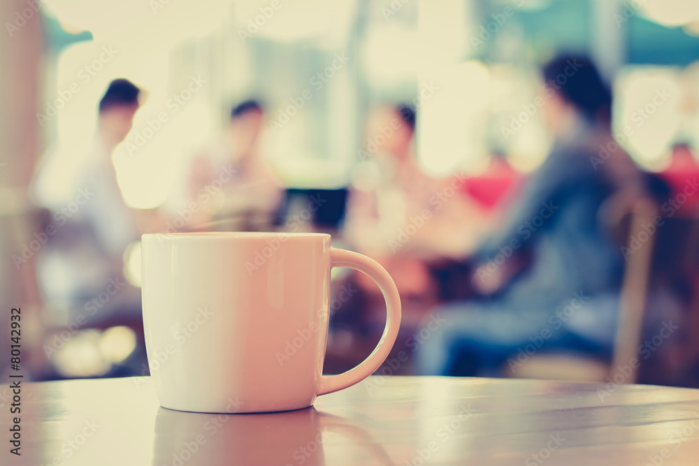 Coffee cup on the table with people in coffee shop -vintage tone Coffee cup on the table with people in coffee shop -vintage tone