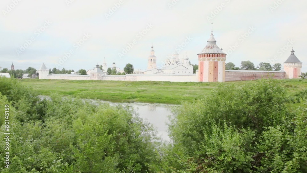 Trees on coast of river with Saviour Prilutskyl Monastery at other side in Vologda, Russia Trees on coast of river with Saviour Prilutskyl Monastery at other side in Vologda, Russia
