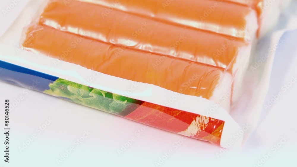 Crabmeat sticks in package spins isolated on white Crabmeat sticks in package spins isolated on white