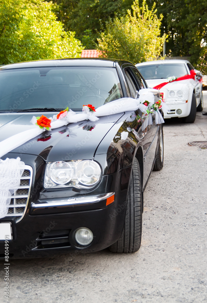 Luxury wedding black and white cars decorated with flowers