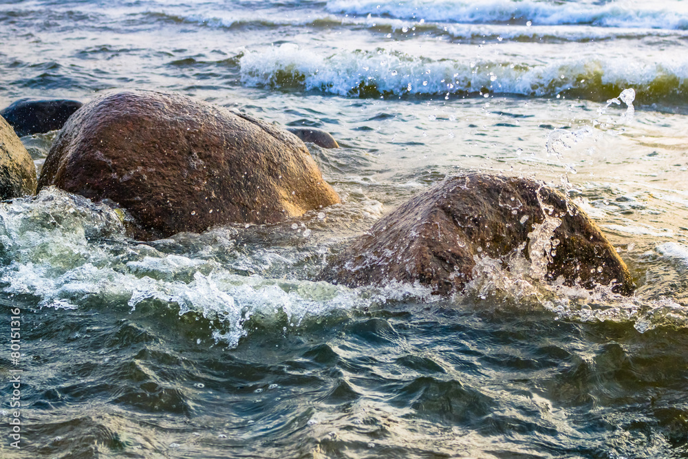 Fototapeta premium Waves crashing against stones