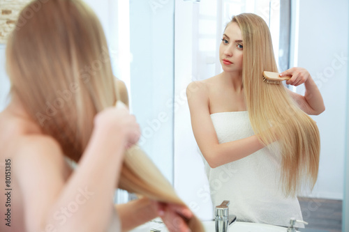 Hair. Beautiful Blond Brushing Her Hair. Hair Care. Spa Beauty 