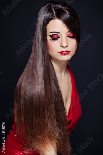Beautiful woman with long brown straight hairs and red dress