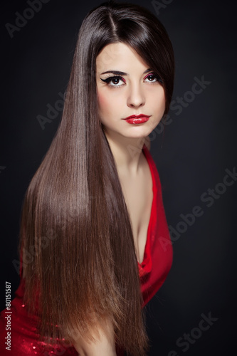 Beautiful woman with long brown straight hairs and red dress