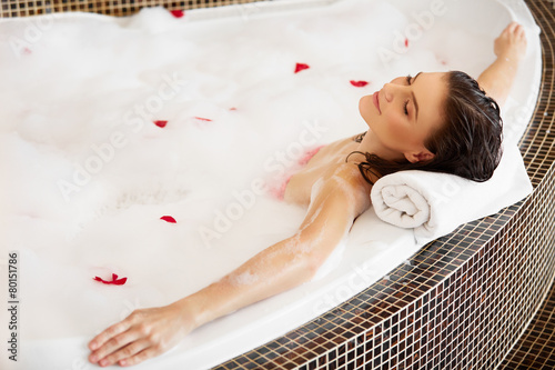Woman Relaxing in Bubble Bath With Rose Petals. Body Care