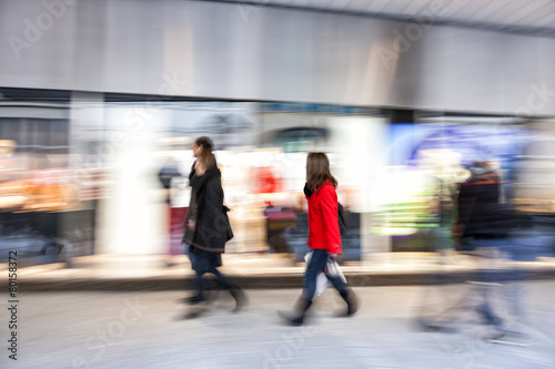 Shopper walking past a store window, zoom effect, motion blur