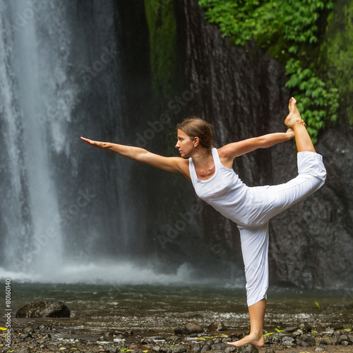 woman meditating doing yoga between waterfalls