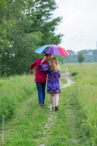 Pregnant couple under an umbrella