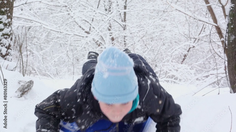 Boy drives from hill in winter on sledges when pushes by hands Boy drives from hill in winter on sledges when pushes by hands
