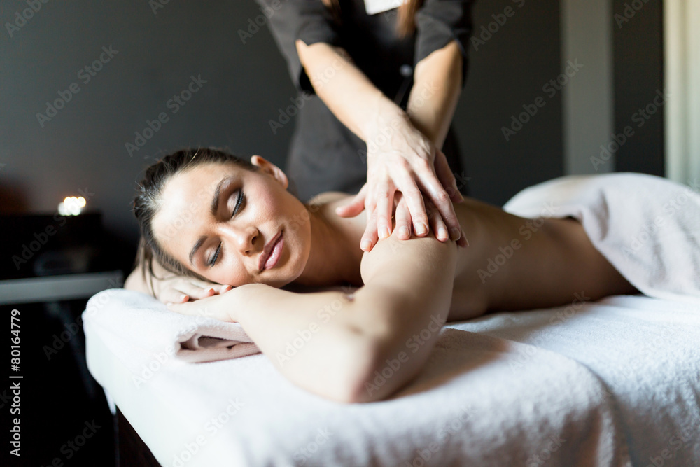 Beautiful, young lady having her shoulder and body massaged Beautiful, young lady having her shoulder and body massaged