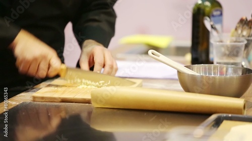 Male hands cut garlic by big knife into small pieces photo