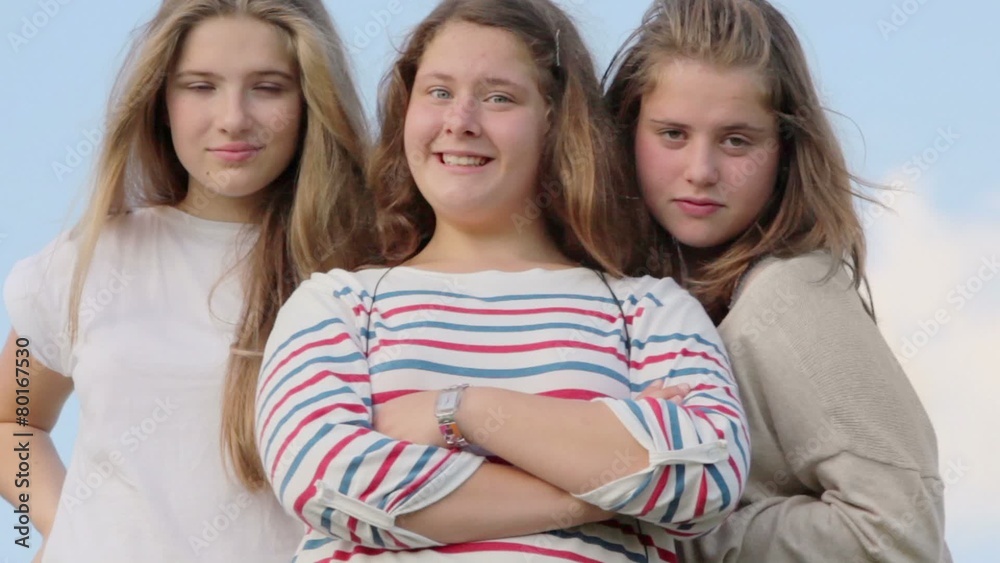 Three girls stand together and watch, closeup view at summer day Three girls stand together and watch, closeup view at summer day