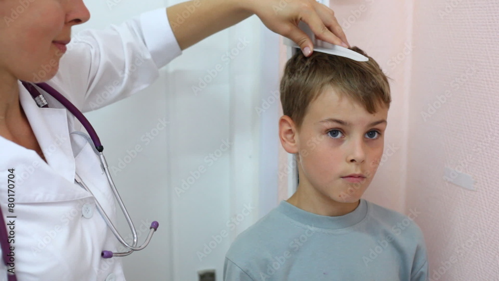 woman doctor measures by big ruler growth of boy close up woman doctor measures by big ruler growth of boy close up