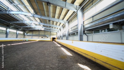 Empty indoor horse riding hangar with sandy covering photo