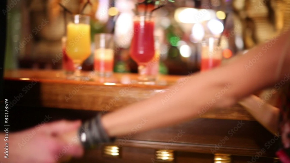 Legs of man and woman near bar counter and taking cocktails Legs of man and woman near bar counter and taking cocktails