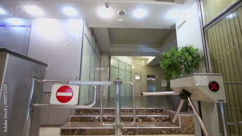 Entrance equipped with turnstile at hall in office building photo