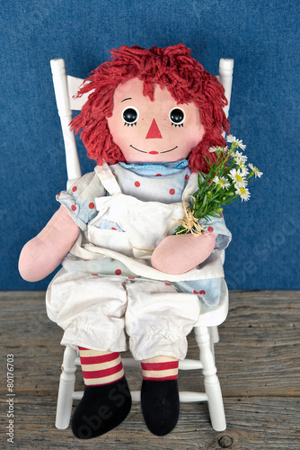 old rag doll with daisy bouquet