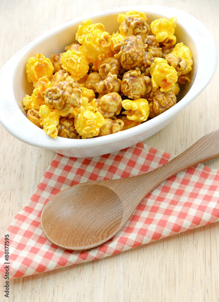 Popcorn in white bowl over wooden background Popcorn in white bowl over wooden background