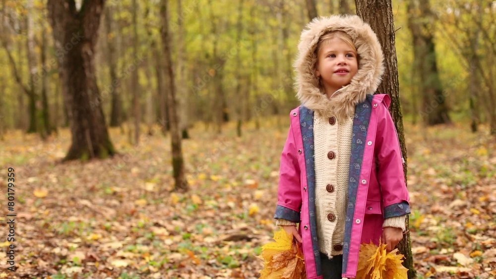 Happy little girl holds yellow maple leaves and sings Happy little girl holds yellow maple leaves and sings