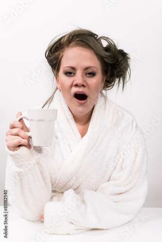 tired woman holding coffee cup in her hand
