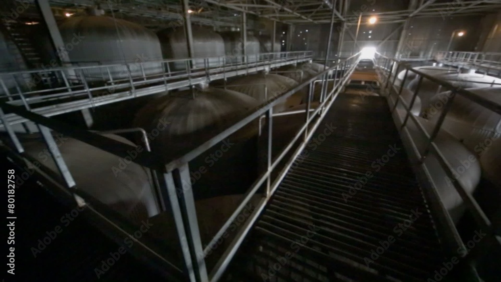 Bridge in dark department with big cisterns for beer Bridge in dark department with big cisterns for beer