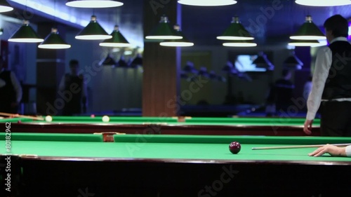 People play billiard game in dark club with few green tables photo