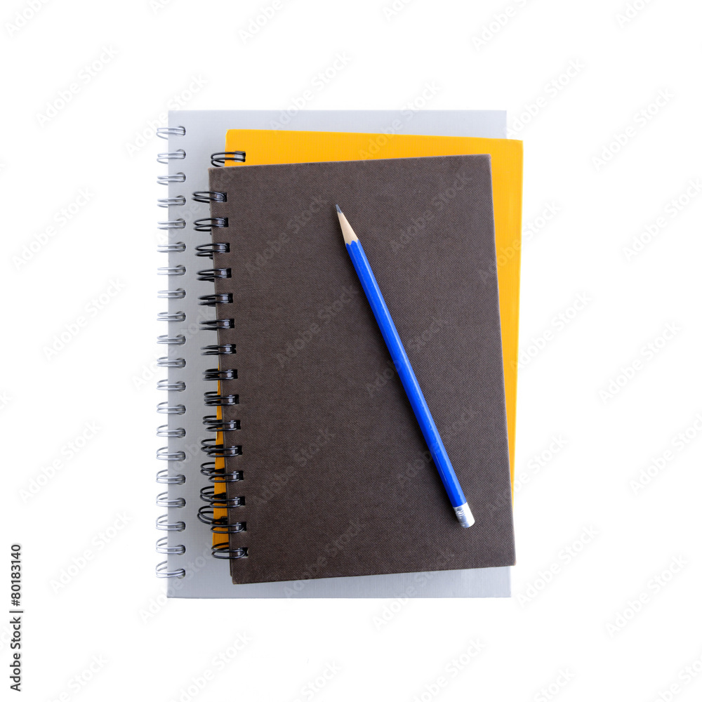 Stack of notebooks or copybooks with pencil on top