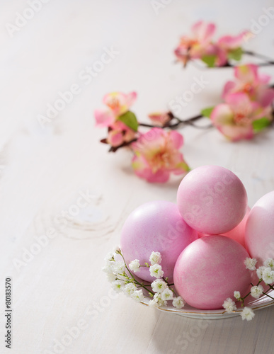 Plate with pink Easter eggs on wooden table.