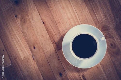 Coffee cup with black coffee on wooden table - vintage tone